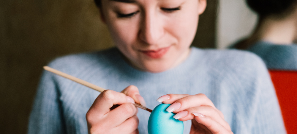 Frau malt Ei blau an