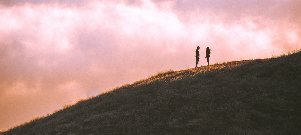 Ein Paar steht sich auf einem Hügel gegenüber