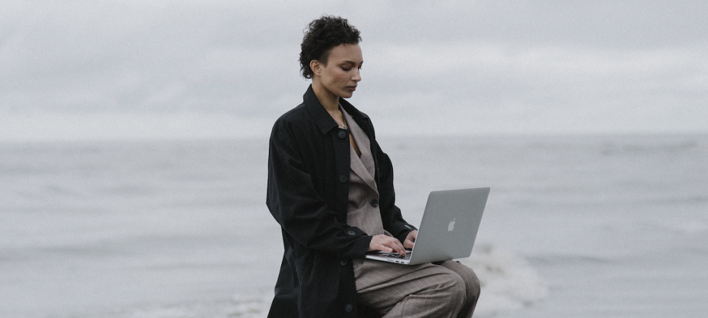 Frau sitzt auf Leiter und arbeitet auf einem Laptop, Rage Applying