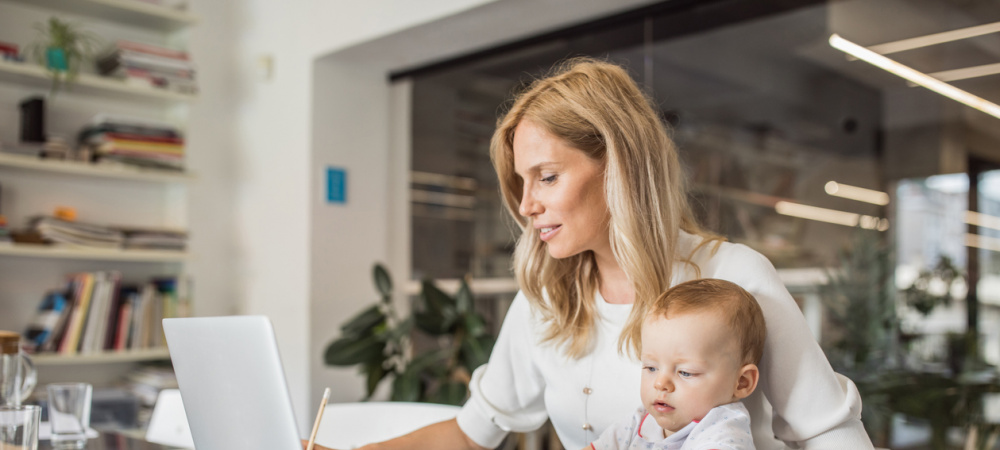 Frau mit Kind vor dem Computer – selbstständig als Mutter