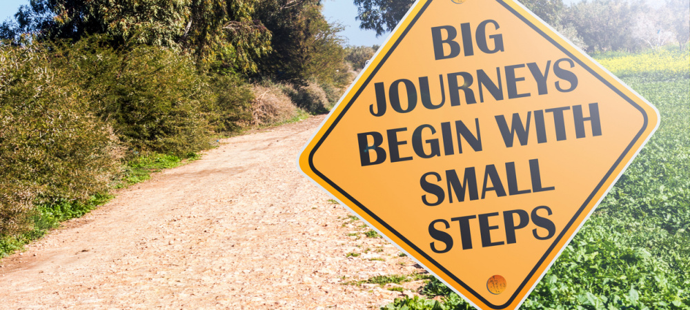 Straßenschild mit der Aufschrift Big Journeys begin with small steps