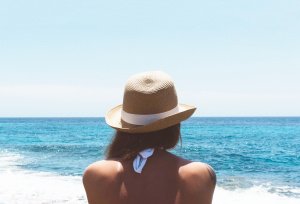 Frau mit Hut am Meer