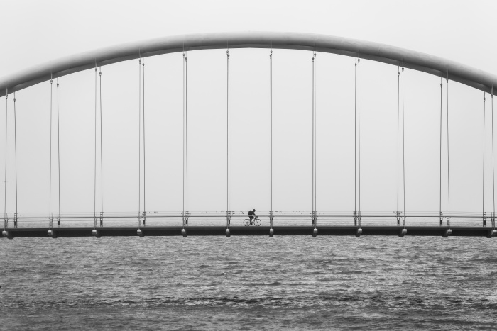 Einsamer Fahrradfahrer auf Brücke