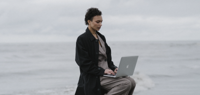 Frau sitzt auf Leiter und arbeitet auf einem Laptop, Rage Applying