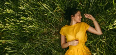 Frau mit gelben Kleid im grünen Feld