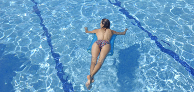Frau liegt auf einer Luftmatratze im Pool