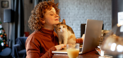 Frau mit Katze am Laptop