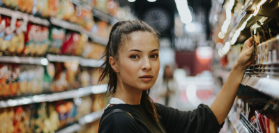 Eine Frau steht an einem Supermarktregal 