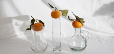 Orangen liegen auf Vasen vor weißem Hintergrund, vegane Snacks