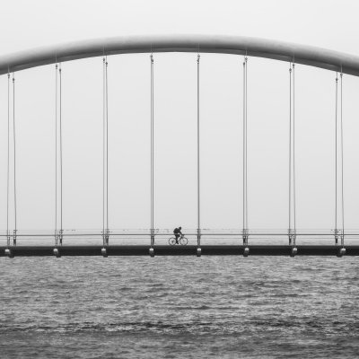 Einsamer Fahrradfahrer auf Brücke