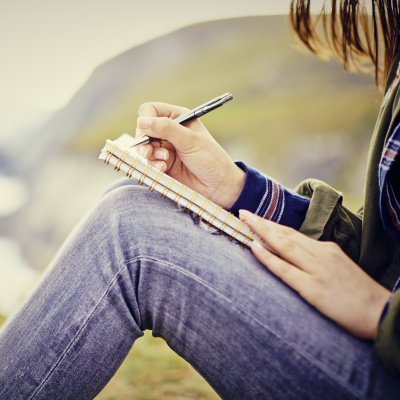 Gute Vorsätze umsetzen: Frau schreibt in Tagebuch