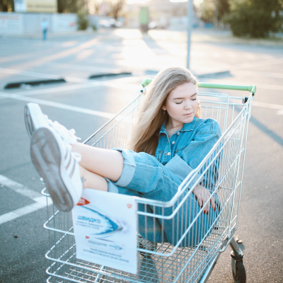 Eine Frau sitzt in einem Einkaufswagen