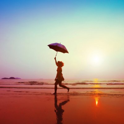 Frau mit Schirm am Strand