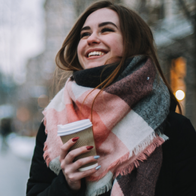 Junge Frau im Winter mit Coffee to go
