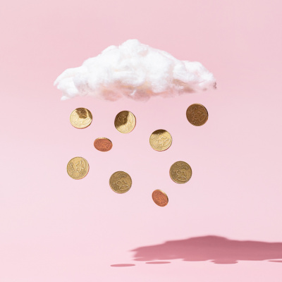 Münzen hängen an einer Wolke aus Watte