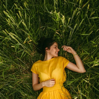 Frau mit gelben Kleid im grünen Feld
