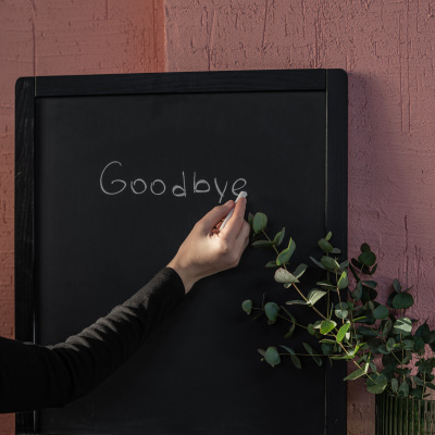 Frau schreibt "Goodbye" auf eine Tafel, richtig kündigen