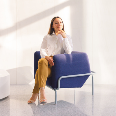 Frau sitzt auf Stuhl, Selbstzweifel im Job loslassen