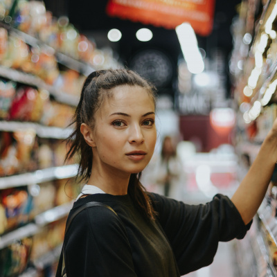Eine Frau steht an einem Supermarktregal 