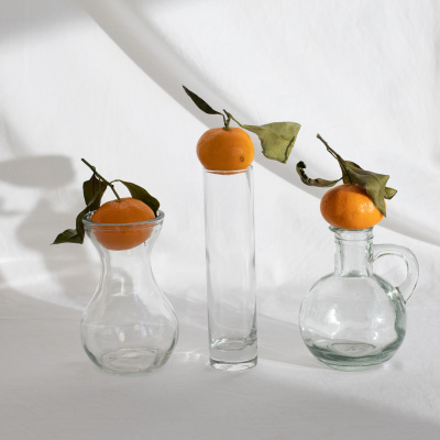 Orangen liegen auf Vasen vor weißem Hintergrund, vegane Snacks